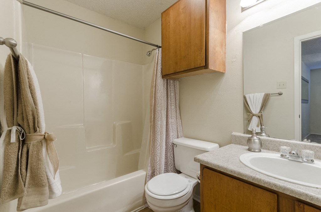 bathroom with wood finishes and shower/tub combo at Arbors Of Cleburne, Cleburne, 76033