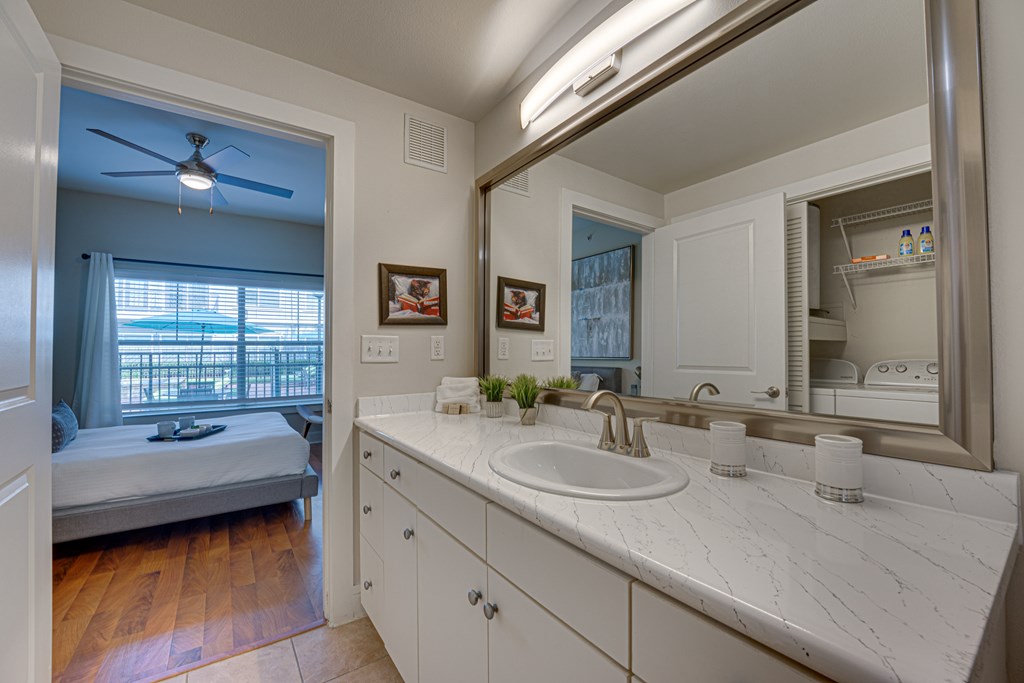 A bathroom with a white sink and a mirror. at Easton Apartments, Dallas, TX