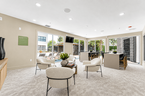 Community clubroom with patio access and seating at The Barton Apartments, Dallas, TX