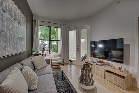 A modern living room with a grey sofa and a television.