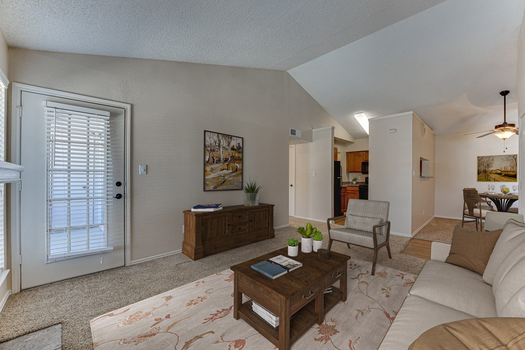 A living room with a couch, coffee table, and a painting on the wall.