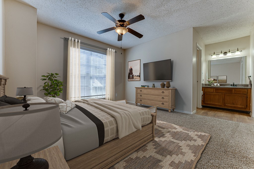A bedroom with a bed, dresser, and ceiling fan.