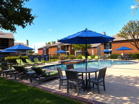 A poolside area with chairs and umbrellas.