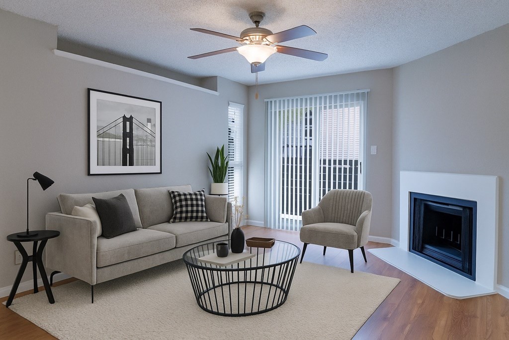 A living room with a grey couch, a chair, a coffee table, and a fireplace.