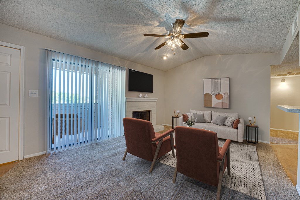 A living room with a fireplace and a television at Indian Creek Apartments, Carrollton 75007
