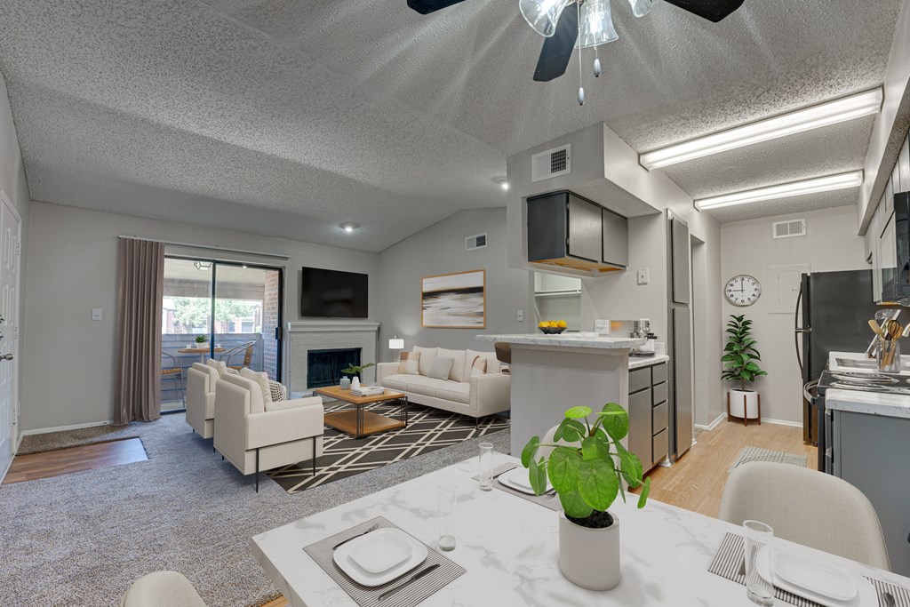 A modern living room with a dining area and kitchen in the background at Indian Creek Apartments, Carrollton
