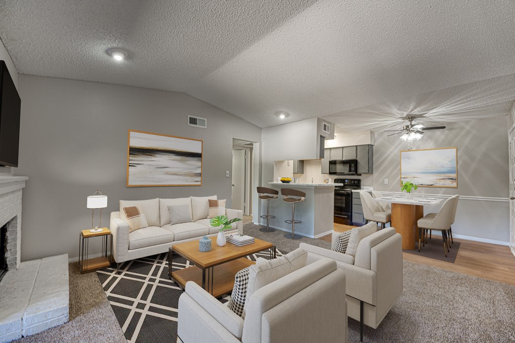 A living room with a fireplace and a dining area at Indian Creek Apartments, Carrollton, Texas