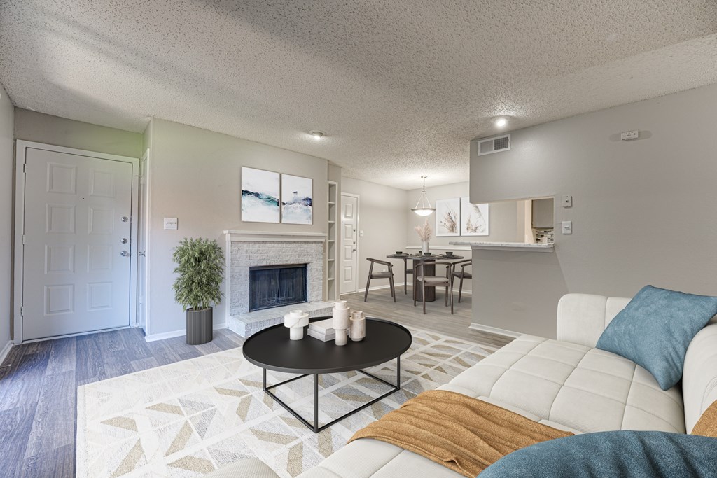 A living room with a white couch and a fireplace at Indian Creek Apartments, Carrollton