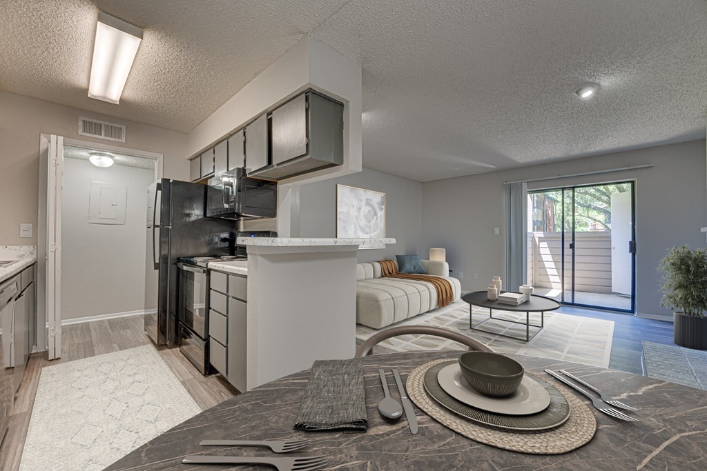 A modern kitchen with a breakfast table set up in the middle at Indian Creek Apartments, Carrollton, TX, 75007