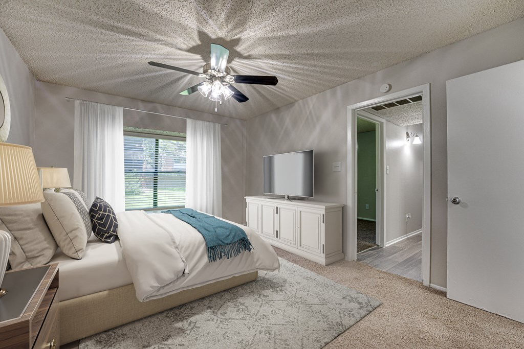 A bedroom with a bed, a ceiling fan, and a cabinet at Indian Creek Apartments, Texas, 75007