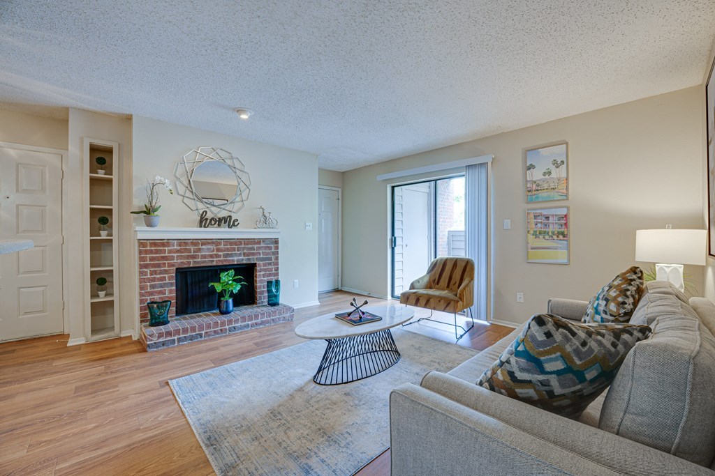 a living room with a fireplace and a sliding glass door at Indian Creek Apartments, Carrollton