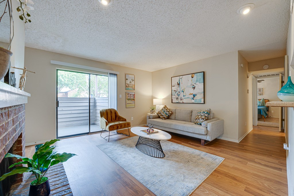 a living room with a couch and a chair and a sliding glass door at Indian Creek Apartments, Carrollton, TX, 75007