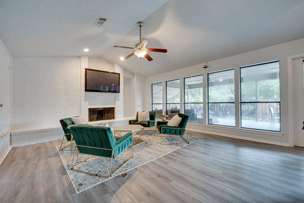 a living room with a large window and a ceiling fan at Indian Creek Apartments, Carrollton, TX