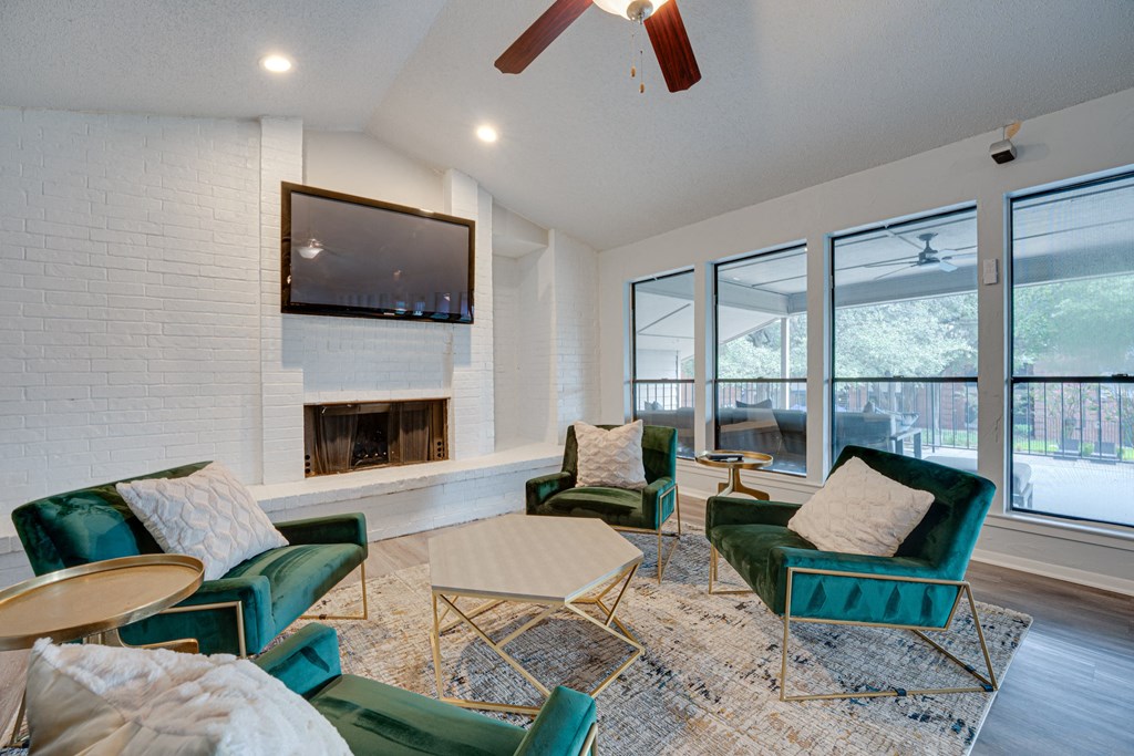 a living room with green chairs and a fireplace at Indian Creek Apartments, Carrollton, Texas