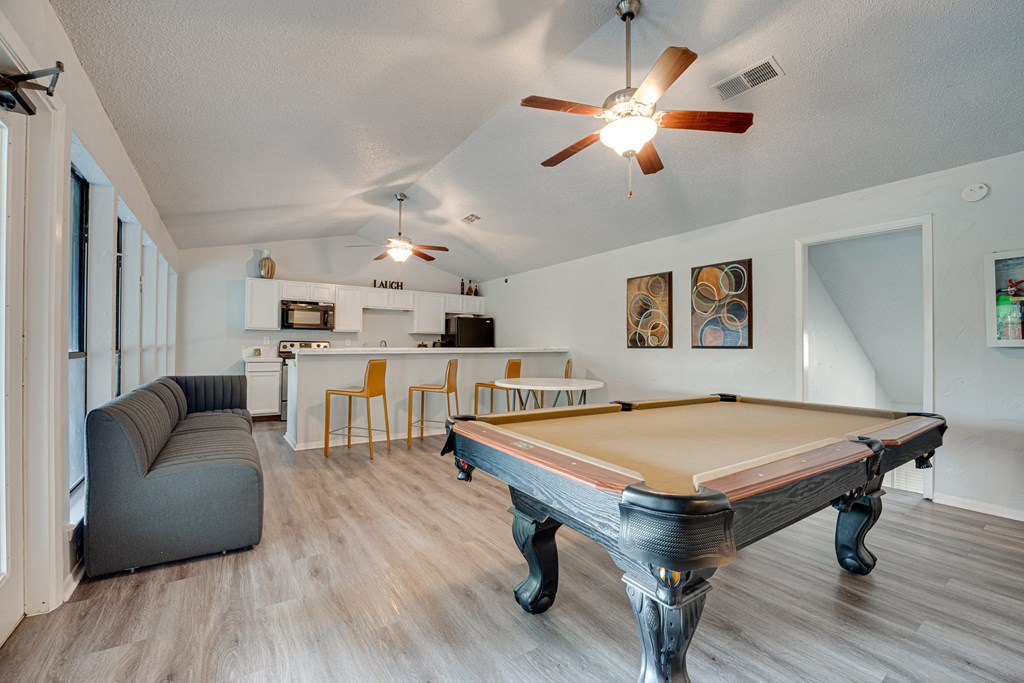 a living room with a pool table and a kitchen with a bar at Indian Creek Apartments, Texas