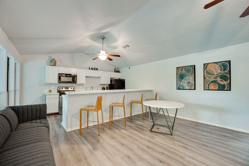 a living room with a kitchen and a dining table at Indian Creek Apartments, Carrollton, 75007
