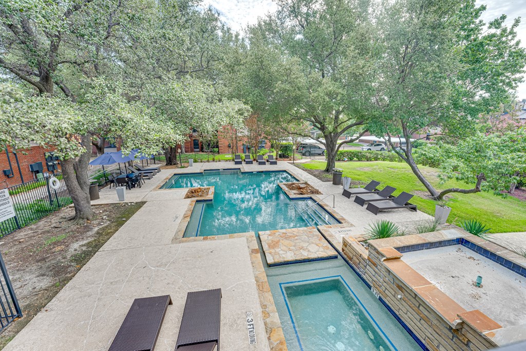 a backyard with a swimming pool and trees at Indian Creek Apartments, Carrollton, TX