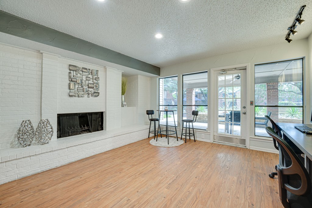 a living room with a fireplace and a wood floor    and a balcony at Indian Creek Apartments, Carrollton, 75007