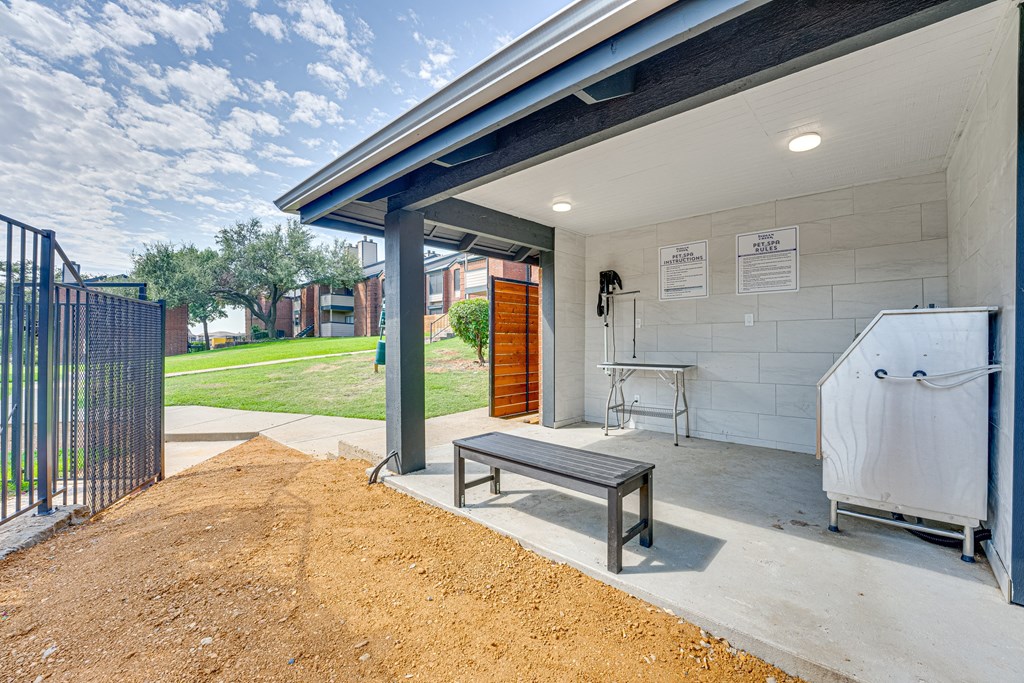 a covered patio with a hot tub and a wooden bench at Indian Creek Apartments, Texas