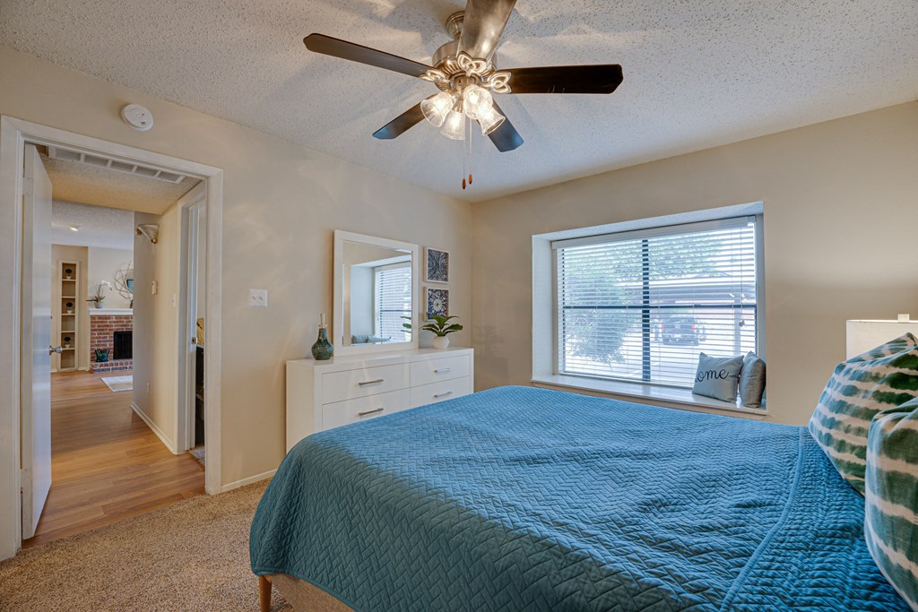 a bedroom with a bed and a ceiling fan at Indian Creek Apartments, Carrollton, Texas