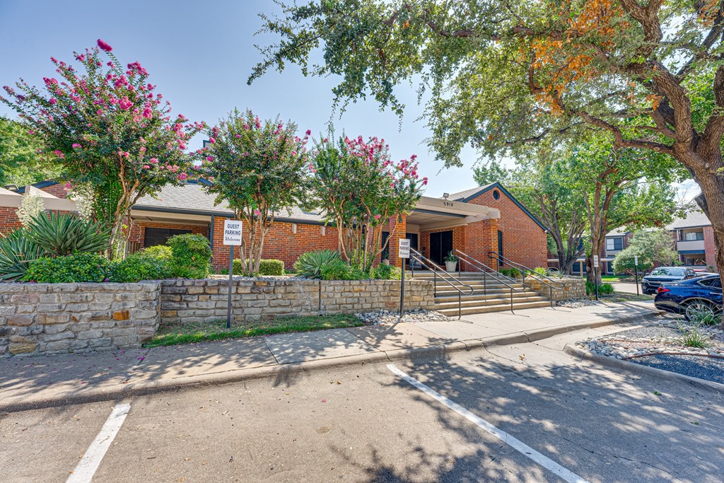 a brick building with trees and a sidewalk in front of it at Indian Creek Apartments, Texas