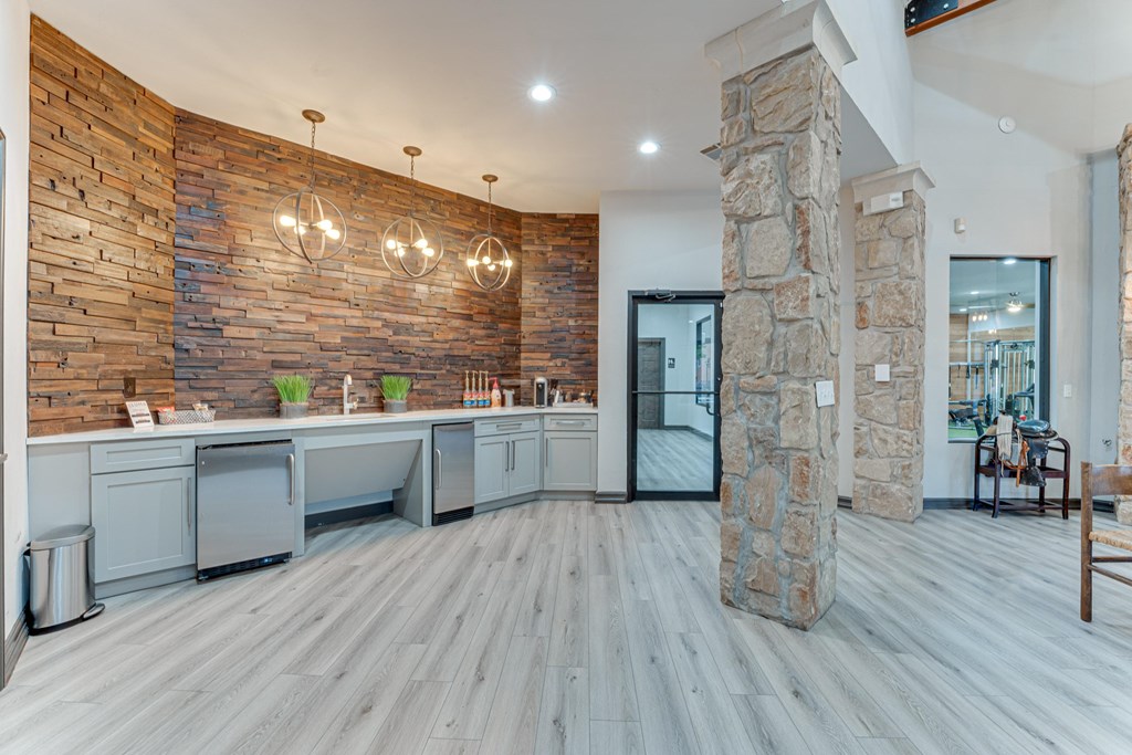 A kitchen with a stone wall and wooden floors at Limestone Ranch Apartments, Lewisville, TX, 75067