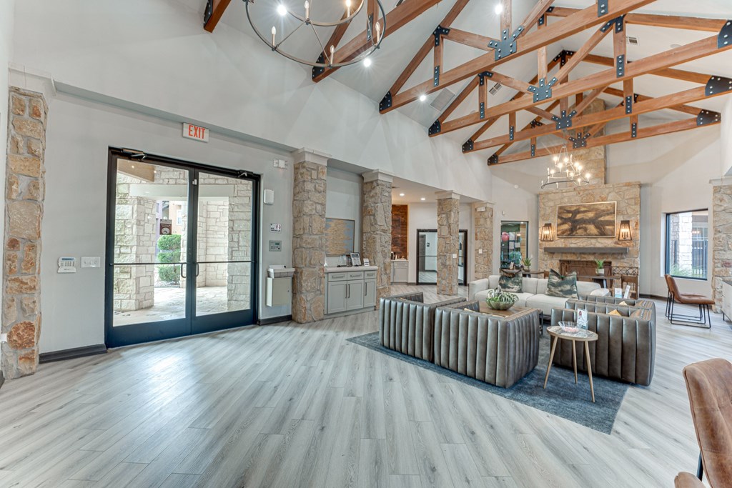 A spacious room with a stone wall and a wooden ceiling at Limestone Ranch Apartments, Lewisville, TX, 75067