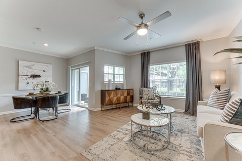 A living room with a white ceiling fan and a coffee table in the middle.