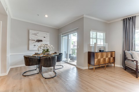 A dining room with a wooden table and chairs.