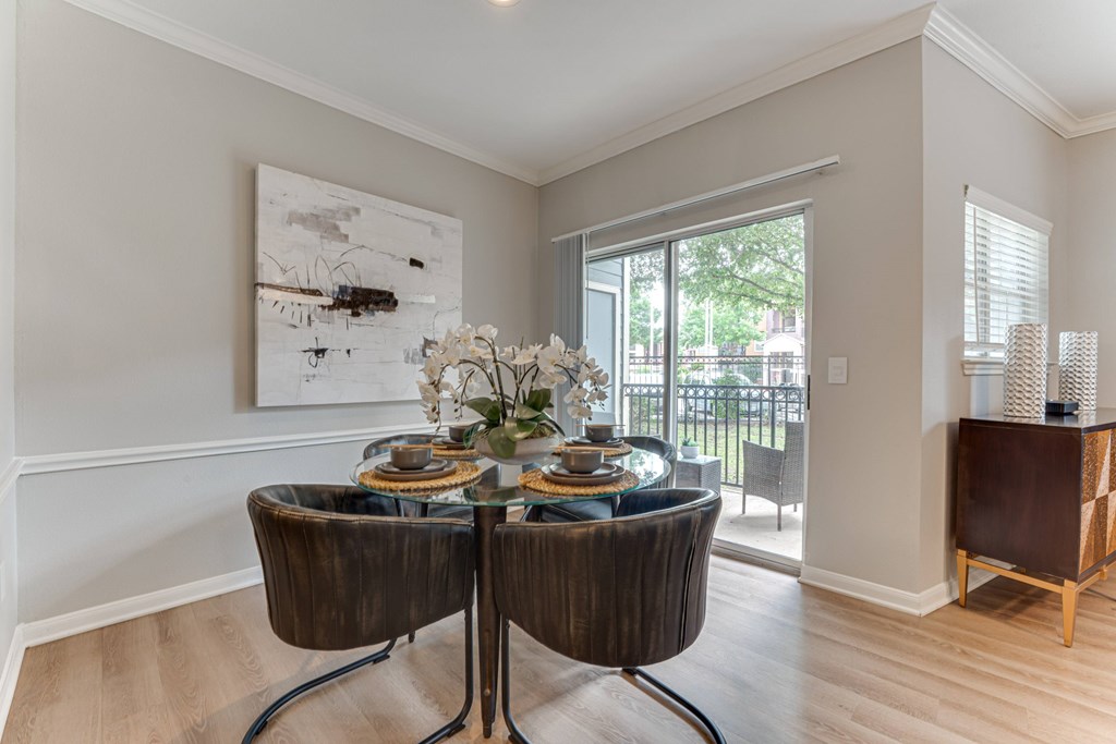 A dining room with a table set for two and a painting on the wall at Limestone Ranch Apartments, Texas, 75067