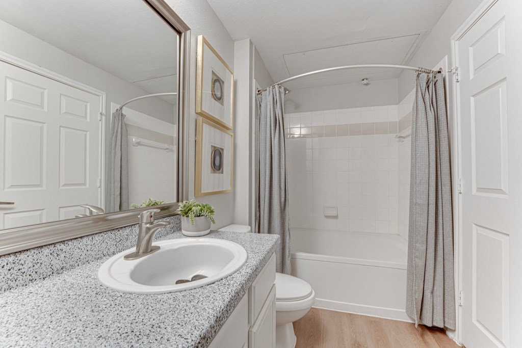 A bathroom with a sink, mirror, and toilet at Limestone Ranch Apartments, Lewisville, TX, 75067