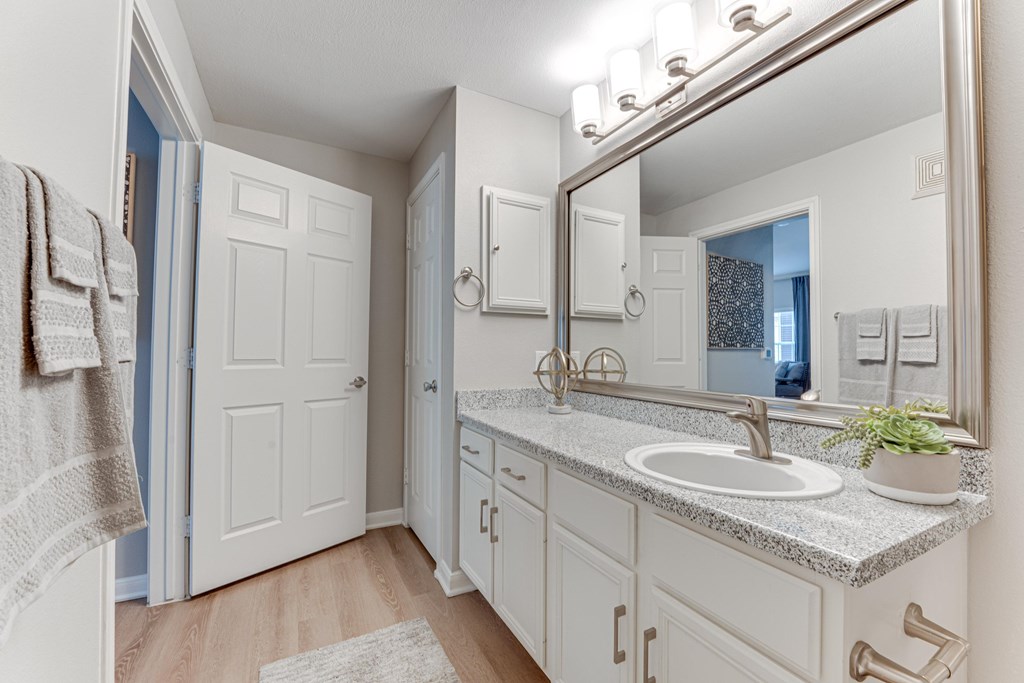 A bathroom with a white sink and a mirror at Limestone Ranch Apartments, Lewisville