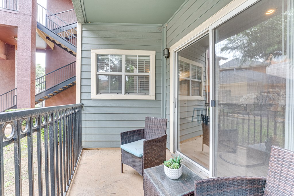 A patio with a table and chairs is shown at Limestone Ranch Apartments, Lewisville, TX, 75067