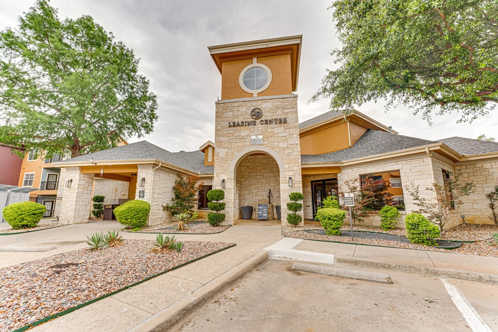 A building with a clock tower in the middle of it at Limestone Ranch Apartments, Texas