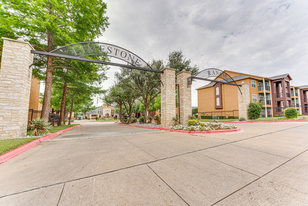 A street view of a residential area with a sign that reads at Limestone Ranch Apartments, Lewisville 75067