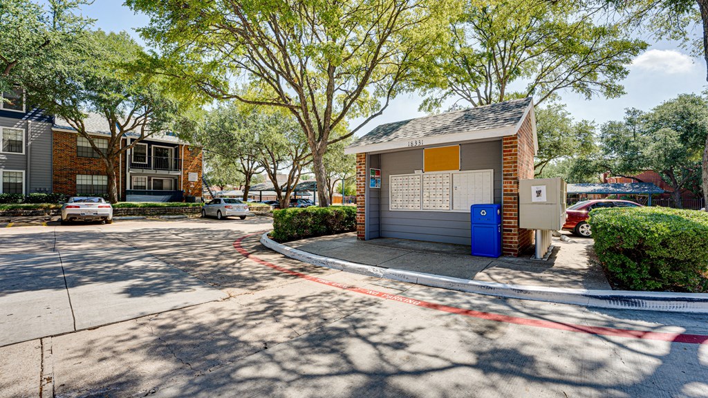 a small bus stop on the side of a street at The Manhattan Apartments, Dallas, TX