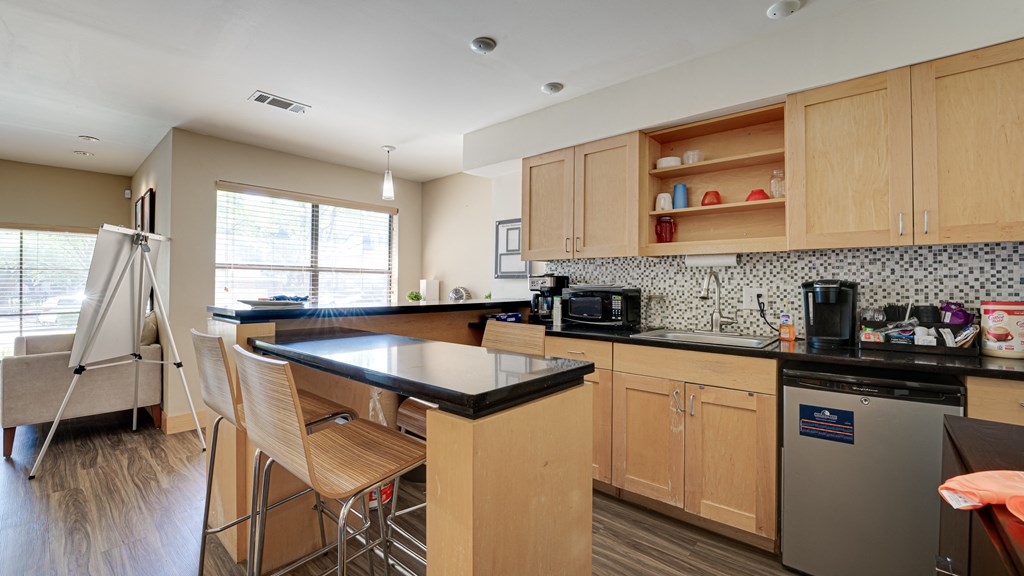 a kitchen with wooden cabinets at The Manhattan Apartments, Dallas, 75252