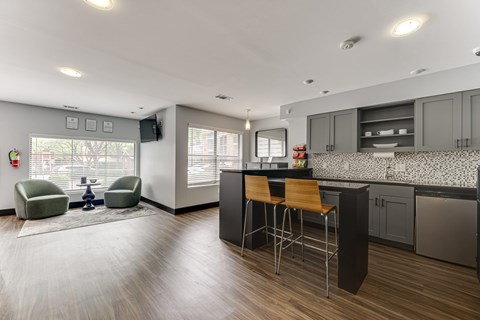 A modern kitchen with a bar stool and a chair. at The Manhattan Apartments, Texas, 75252