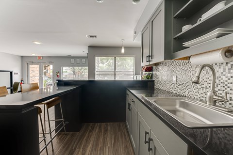 A kitchen with black cabinets and a white countertop. at The Manhattan Apartments, Dallas, TX, 75252
