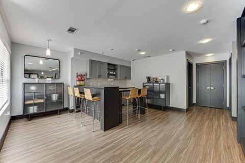 A modern kitchen with wooden floors and a central island. at The Manhattan Apartments, Dallas, TX