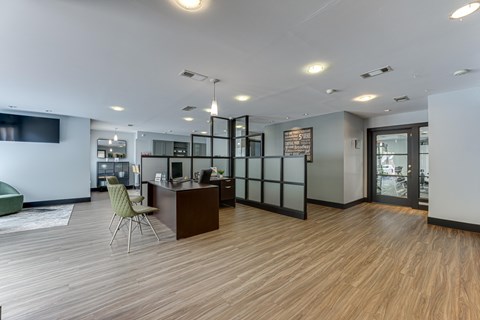 A modern office space with a wooden floor and a green chair. at The Manhattan Apartments, Dallas, Texas