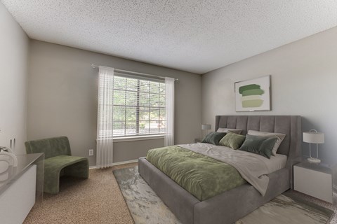 A bedroom with a large bed and a green chair.