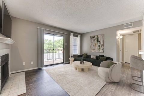 A living room with a fireplace and a couch. at The Manhattan Apartments, Dallas, TX, 75252