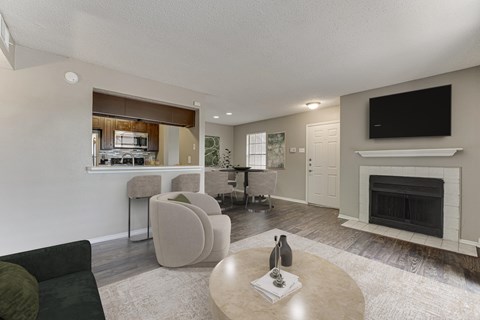 A living room with a fireplace and a television. at The Manhattan Apartments, Dallas, Texas
