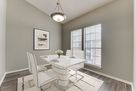 A dining room with a white table and chairs.