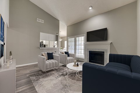 A living room with a fireplace and a television. at The Manhattan Apartments, Dallas, Texas