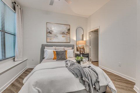 Bedroom with upholstered bed and abstract artwork at The Montrose Apartments, Dallas, TX 75204