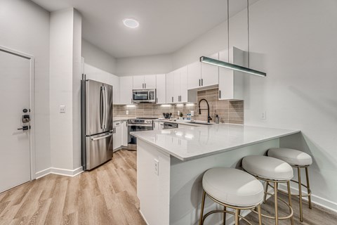 A kitchen with white cabinets and a white counter top.