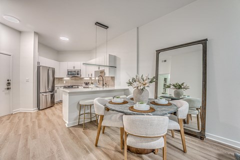 A modern kitchen with a dining table set for two.