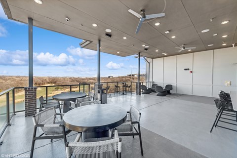 A patio with a table and chairs overlooking a body of water.